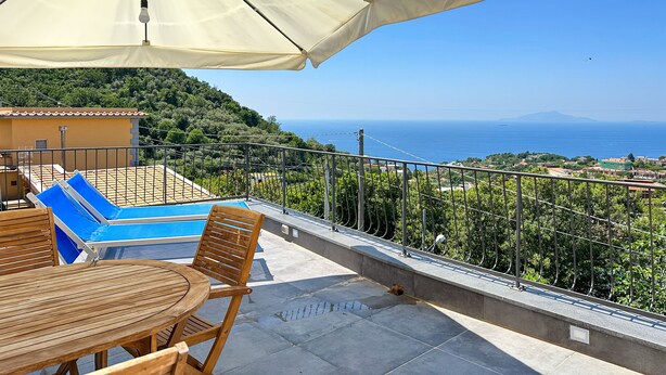 A terrace with a pool, wooden furniture, and a view of the sea. - La Campanella (Massa Lubrense)