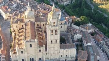 Vista aérea de una catedral histórica con múltiples agujas y una gran cúpula central, rodeada por una zona urbana densa con calles estrechas y edificios residenciales.