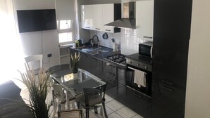 Cocina moderna con estufa a gas, microondas y gabinetes negros.