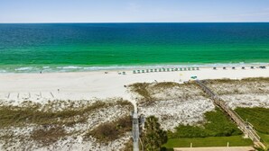 A beach with a wooden boardwalk leading to beach umbrellas and chairs. - Canalfront, Boat slip, Hot Tub, SUPs, Dogs, Beach (Destin)
