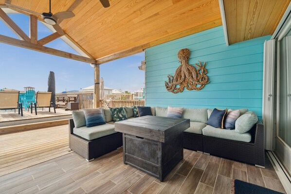 Un espace extérieur abrité, doté d’un plafond en bois, d’un mur de couleur turquoise et d’une sculpture décorative représentant un poulpe.