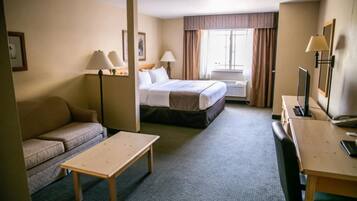 Ein Hotelzimmer mit Bett, Sofa, Schreibtisch und Lampe.