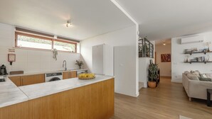 A modern kitchen with a wooden island, built-in appliances, and a dining area with a sofa and a coffee table.
