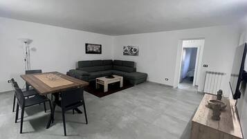 Un soggiorno moderno con un tavolo da pranzo, un divano e un tavolino.