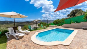 A swimming pool with lounge chairs and a pergola. - Casa de la Cruz Iznájar by Ruralidays (Córdoba)