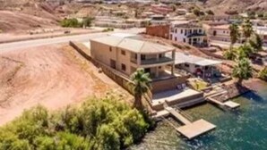 A coastal property with a large building, a swimming pool, and a dock.