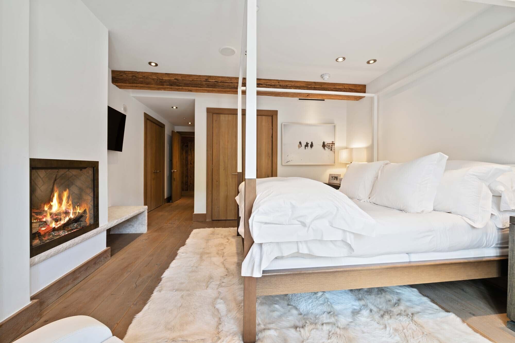 Een moderne slaapkamer met een open haard, een bed en een gang.