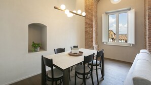 Spiseplads med murstensvæg, et vindue med udsigt og en hængende lampe.