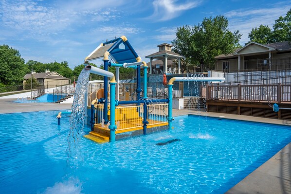 Guests can enjoy a fun-filled day at the pool with a water play structure featuring slides and climbing elements.