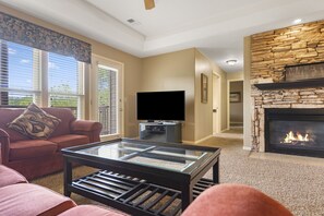 Relax by the fireplace in this cozy living room with a comfortable sofa, flat-screen TV, and coffee table.