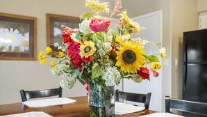 A dining table with a vase of flowers in the center. - Golf Condo for Two at Beautiful StoneBridge Village Resort (Reeds Spring)