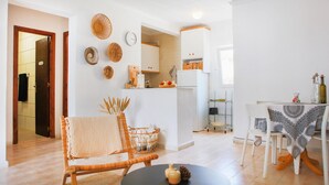 Uma cozinha moderna com armários brancos, uma porta de madeira e um espaço de jantar com mesa e cadeiras.