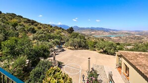 Ein Innenhof mit Basketballplatz, umgeben von viel Grün und einer Bergkulisse.