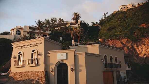 A building with a sign reading "UN LUGAR PARA CONOCER EL PASADO Y DISFRUTAR EL PRESENTE" and "OBERTOSIO HOTEL". - Torre M (Mazatlán)