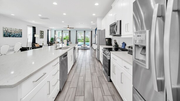 A modern kitchen with white cabinetry, stainless steel appliances, and a central island. - Modern Family Villa With Private Pool and Hot Tub (Reunion)