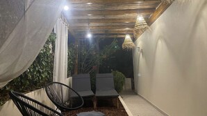 An outdoor seating area with two chairs and a table, a woven ceiling, and hanging lights. - Vila Luisa Anabela 6/8 Personnes Piscine et Jacuzzi (Albufeira)