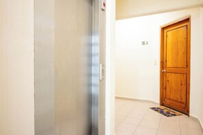 A hallway with a wooden door labeled 'B 1' and a doormat with 'Welcome' written on it. - Costa brava  (Puerto Aventuras)