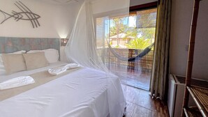 Une chambre avec un lit, un hamac et une vue sur l’extérieur.