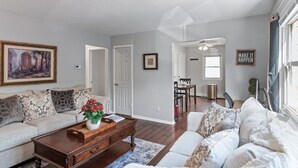 Un salon avec un canapé, une table basse et un tableau accroché au mur.