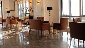 En rymlig entréhall med moderna möbler, stora fönster och stilfulla belysningsarmaturer.