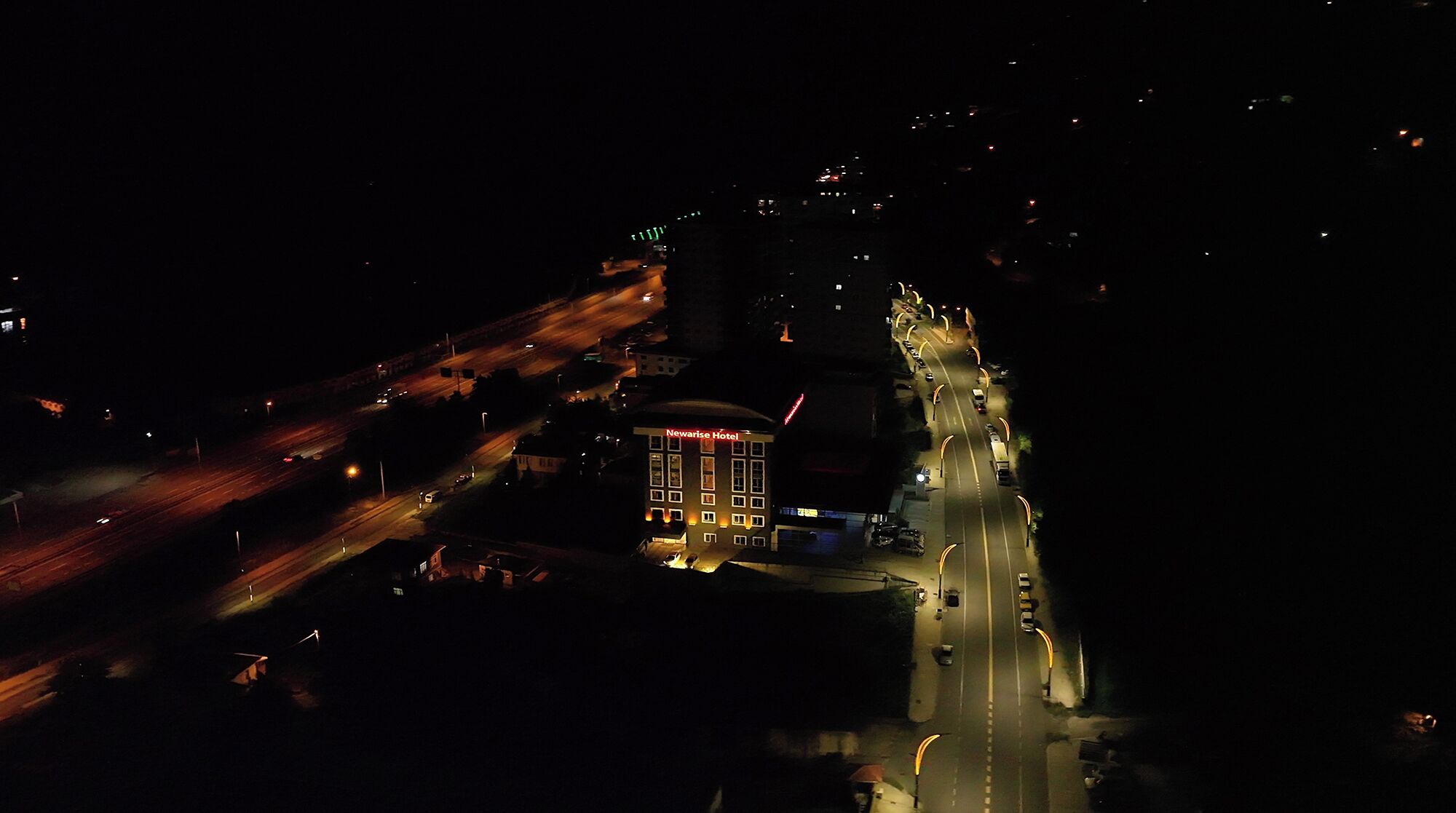 Luchtbeeld van een hotel met een opvallend gebouw, genaamd 'Newaris Hotel'.