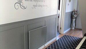A hallway with a decorative wall quote, a radiator, a patterned floor, and a piano. - Cleomack House
Home from Home @Mourne Mountains  (Hilltown)
