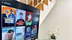 Ein Flachbildfernseher zeigt verschiedene Netflix-Serien mit Titelangaben und Schauspielerinformationen.