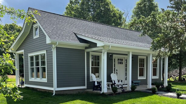 A two-story house with a covered porch and a well-maintained lawn. - The Cottage At Hershey Lane Farm (Frenchtown)
