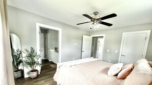 A bedroom with a bed, a ceiling fan, and two potted plants. - Modern home near downtown Hendersonville (Hendersonville)