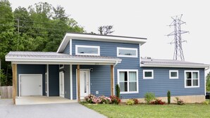 A two-story house with a garage, a covered porch, and a well-maintained lawn. - Modern home near downtown Hendersonville (Hendersonville)