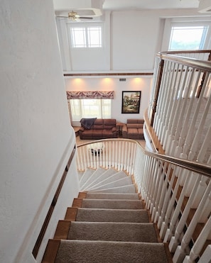 Stairs lead to a cozy living space with a sofa and framed artwork.