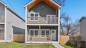 A two-story residential building with a balcony on the upper floor, a front door, and a visible number "121" on the right side. - NEW Four Bedroom Nashville Downtown house to enjoy 2 mins to Broadway. (Nashville)