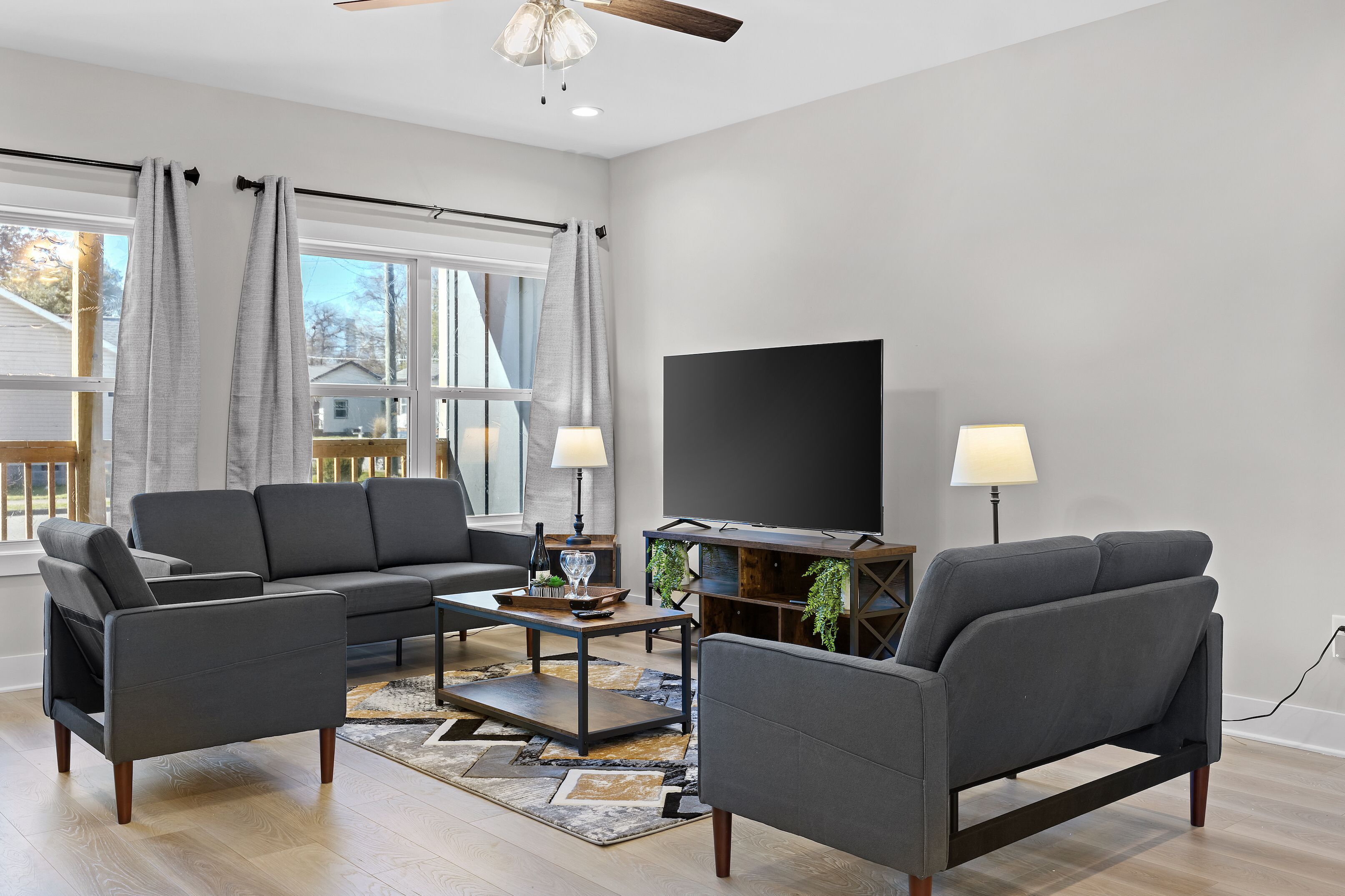 Een moderne woonkamer met een modulaire bank, een salontafel en een televisie.