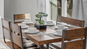 A dining table set with white plates, bowls, and a bonsai tree centerpiece. - NEW Four Bedroom Nashville Downtown house to enjoy 2 mins to Broadway. (Nashville)