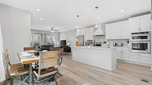 A modern kitchen with white cabinets, a central island, and built-in ovens. - NEW Four Bedroom Nashville Downtown house to enjoy 2 mins to Broadway. (Nashville)
