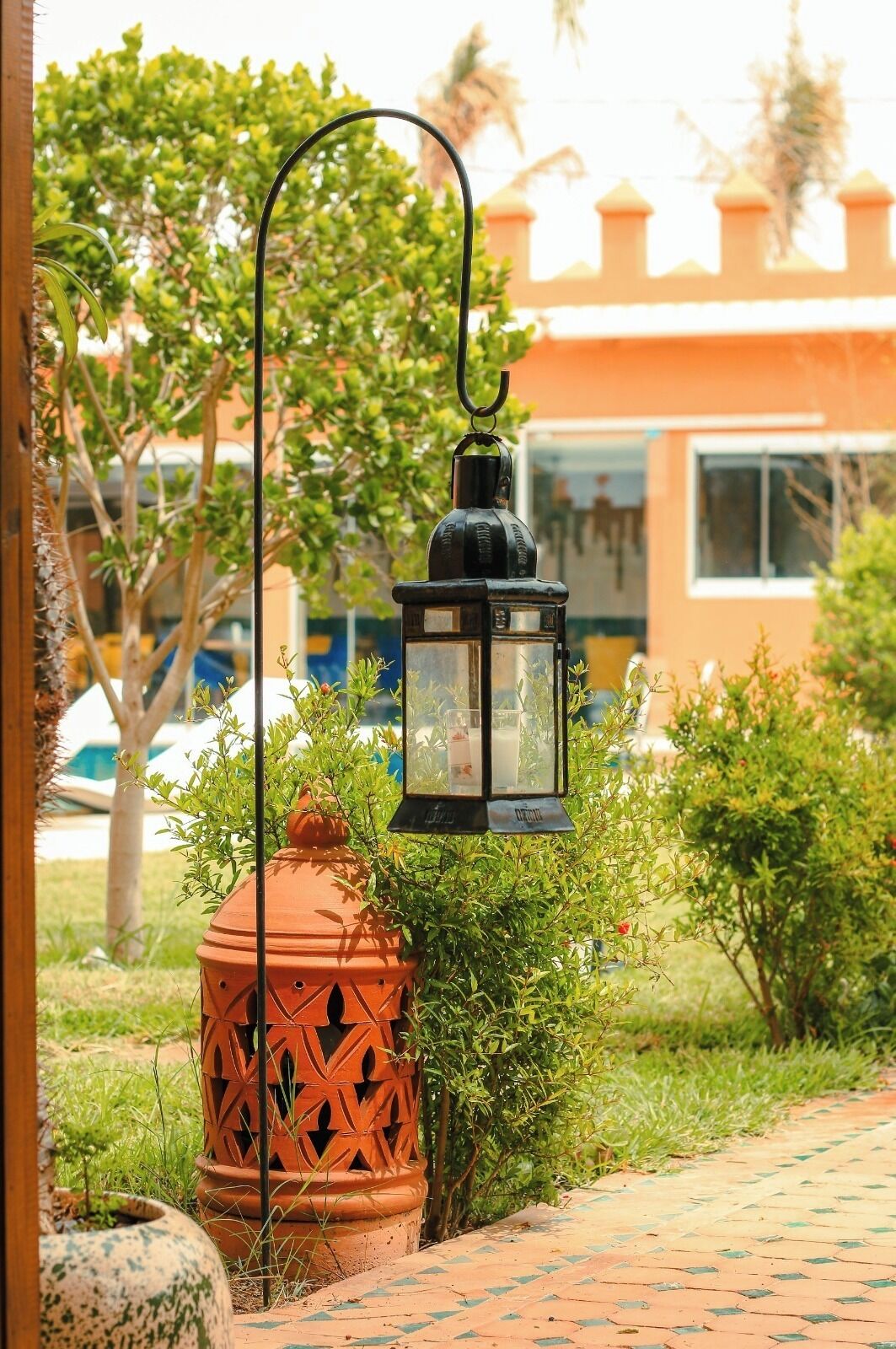 A garden pathway with a decorative lantern and a terracotta pot.