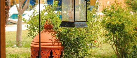 A garden pathway with a decorative lantern and a terracotta pot.