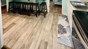Cocina compacta con comedor, cafetera y refrigerador.