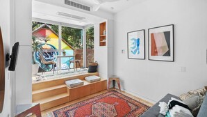 Una sala de estar moderna con un ventanal grande, un ventilador de techo y una alfombra colorida.