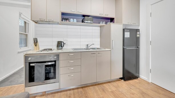 A modern kitchen with a built-in oven, a refrigerator, and a countertop with a kettle and coffee maker. - Perfect base for your Melbourne Adventure! Walk to the MCG, CBD, Richmond... (Richmond)