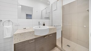 A modern bathroom with a large mirror, a round sink, a shower, and a towel rack. - Perfect base for your Melbourne Adventure! Walk to the MCG, CBD, Richmond... (Richmond)
