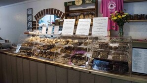 A bakery display with various baked goods and a sign for 'Wildflour Bakery'. - Luxury Treehouse 20 miles from asheville.  (Saluda)