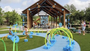 An outdoor play area with a wooden pavilion, slides, and various play structures. - Modern Farmhouse • Chef Kitchen • GameRoom • 77" OLED • BBQ Grill  (Katy)