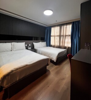 A hotel room with two beds, a desk, and a window with curtains. - Hennessy Hotel (Hong Kong)
