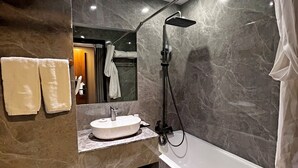 A modern bathroom with a marble vanity, a freestanding bathtub, and a toilet. - Hennessy Hotel (Hong Kong)
