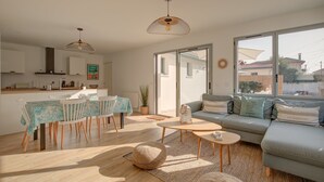 Una sala de estar moderna con sofá, mesa de centro y comedor.
