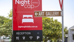 Segnaletica per Nightcap Hotels con indicazioni per la Galleria d'Arte e la Reception.