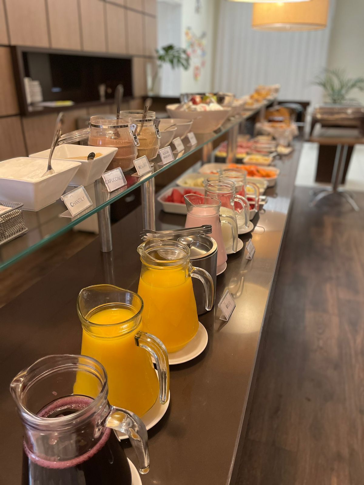 A buffet with various food and drink options, including juices and a salad bar.
