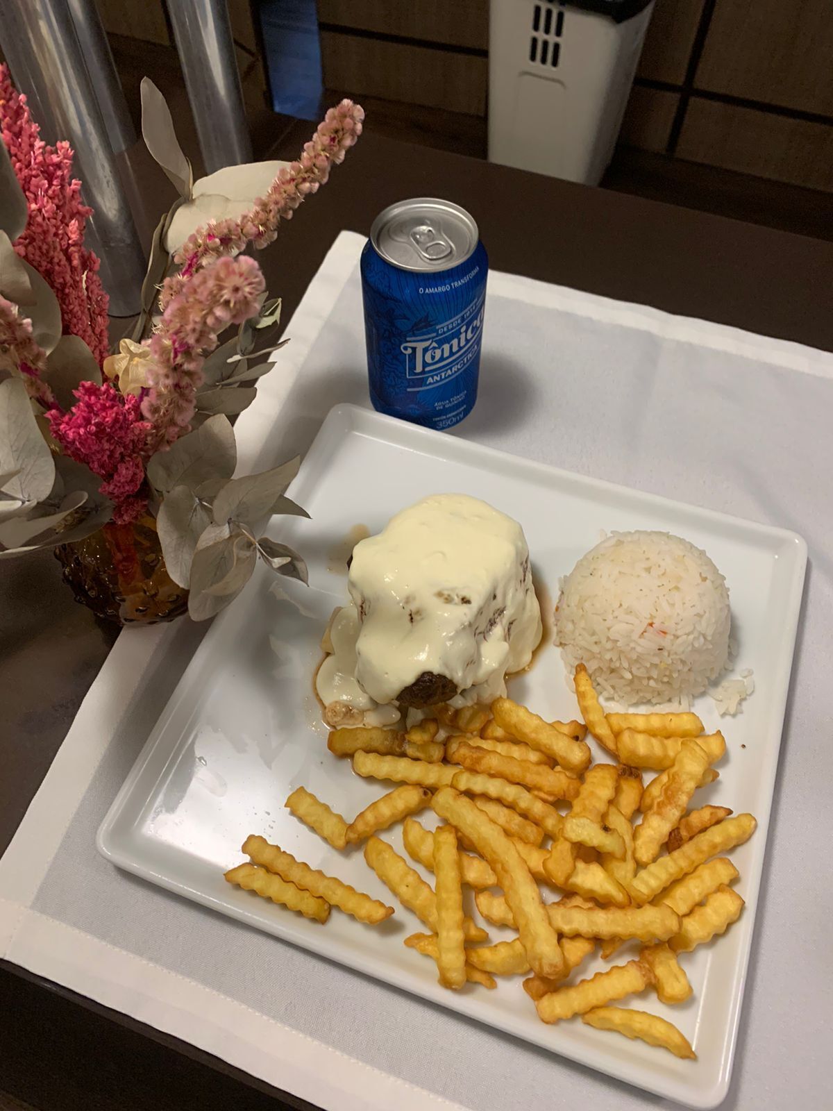 Ein Teller mit einem Fleischgericht, Reis und Pommes Frites, dazu eine Dose Tonic.