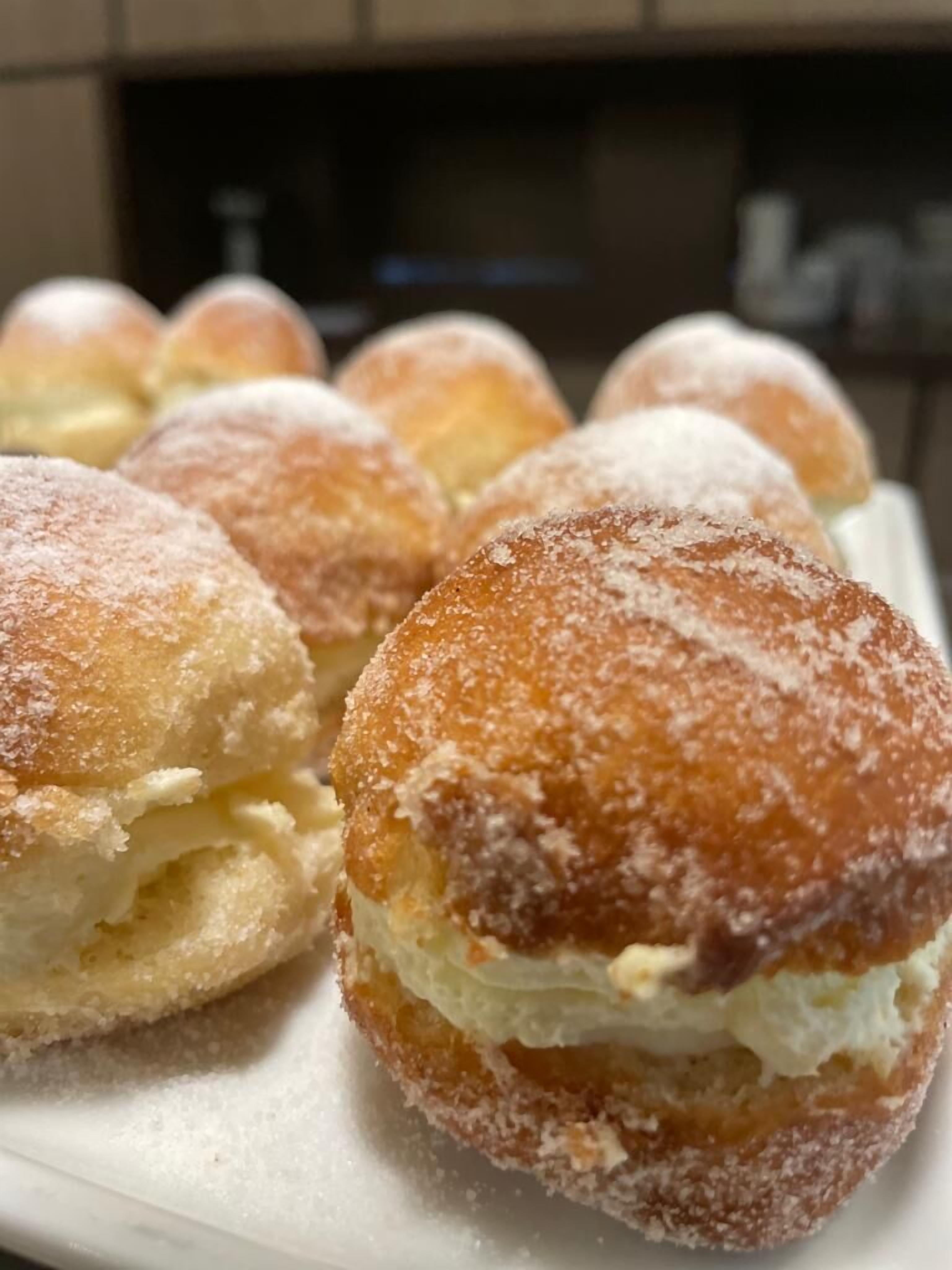 A plate of cream puffs dusted with powdered sugar.